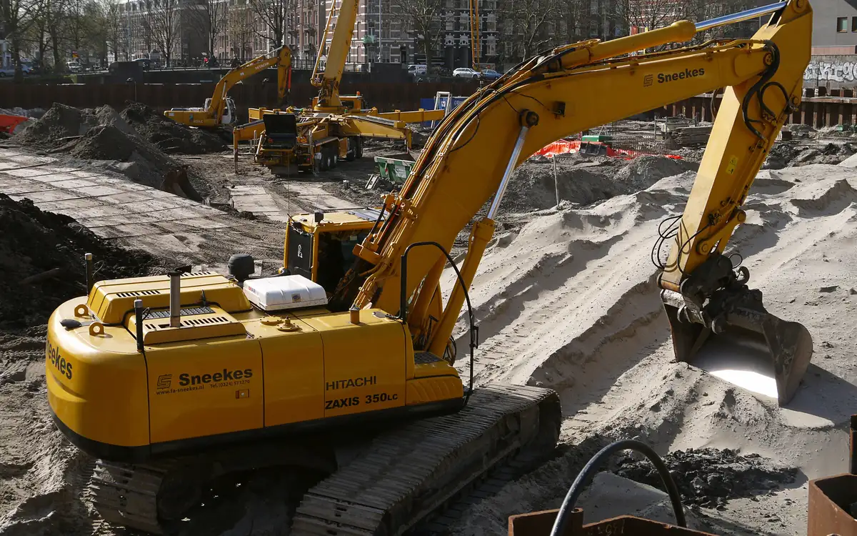 Excavator digging sand on a large urban excavation site