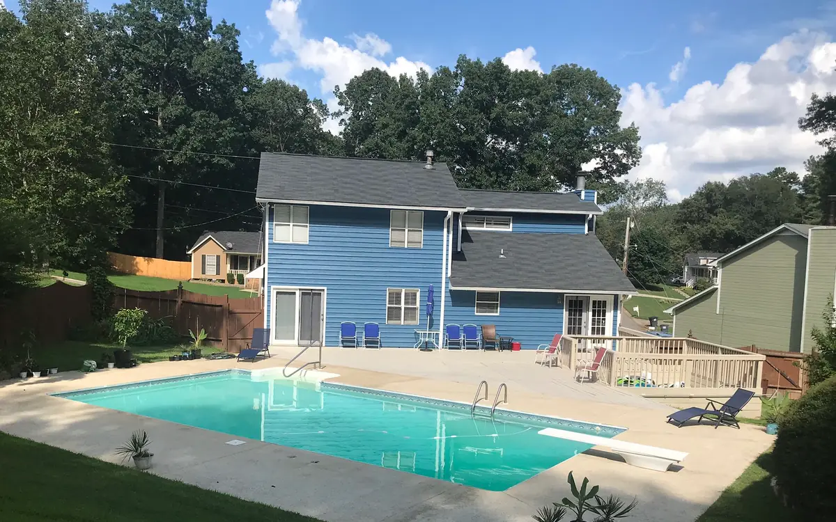 Rectangular in-ground swimming pool behind a two-storey house