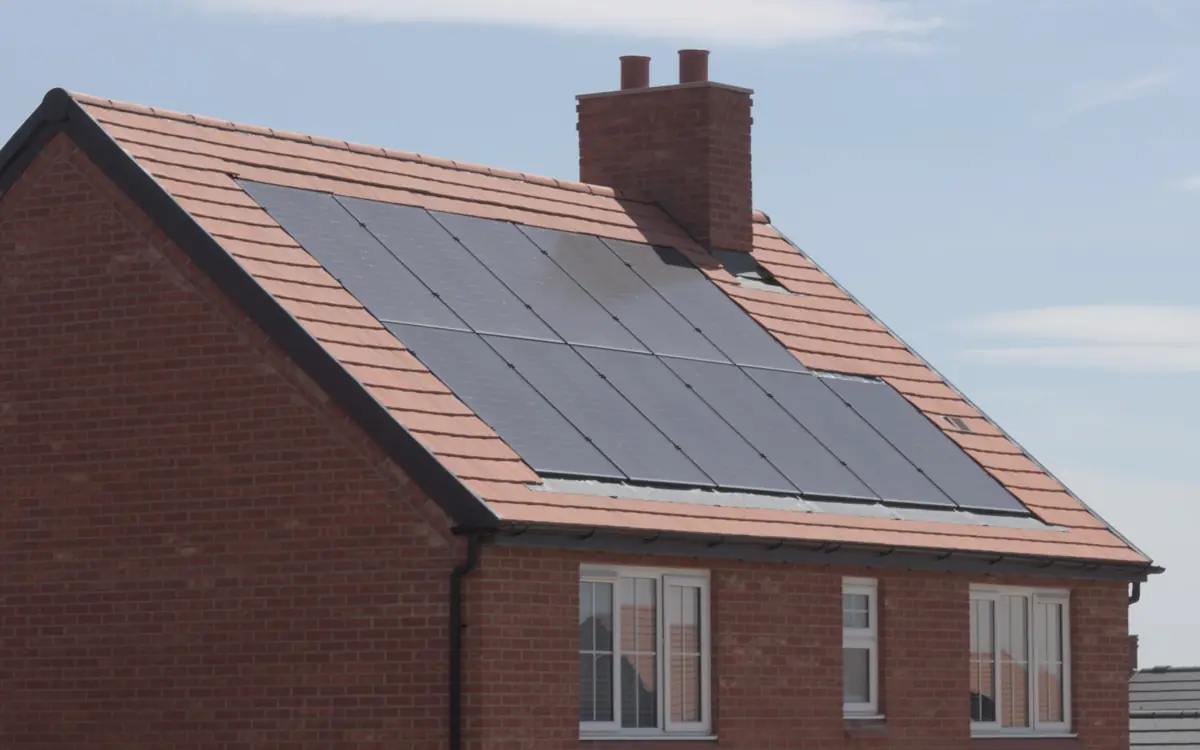 Solar panels set into a pitched tile roof on a brick house